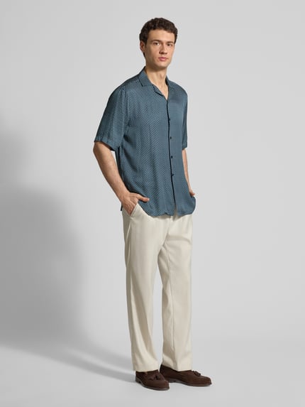 Männermodel trägt Regular Fit Freizeithemd aus Viskose von CRUNA in Blau mit Muster, Reverskragen, Knopfleiste, kurzärmelig, ganzkörperansicht von vorne.
