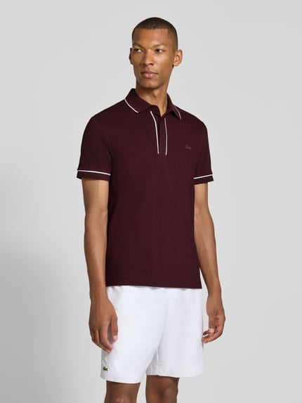 Mannelijk model draagt Regular Fit poloshirt uit katoenmix van Lacoste in bordeaux met witte accenten, heren poloshirt, geheel vooraanzicht.