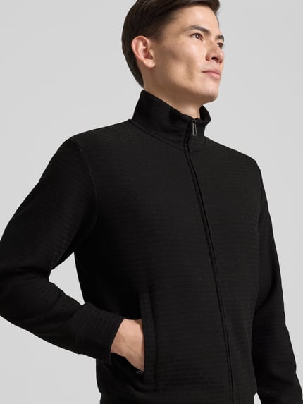 Männermodel trägt Sweatjacke mit Stehkragen von Emporio Armani, Schwarz, Baumwoll-Lyocell-Mix mit Stretch-Anteil, Reißverschluss, Eingrifftaschen, gerippte Abschlüsse, lockerer Schnitt, Rückenlänge 64 cm, Ärmellänge 60 cm, Nahaufnahme Oberkörper.