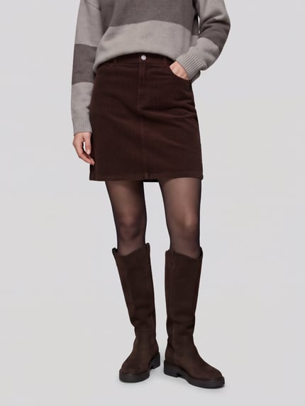 Frauenmodel trägt Rock mit Cordstruktur von S.OLIVER CASUAL in Braun, unifarben, Mini-Länge, 5-Pocket-Design, Ganzkörperansicht von vorne.