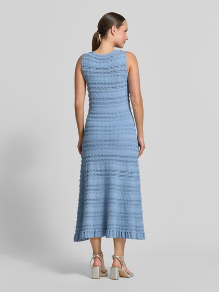 Kobiece model prezentuje sukienkę midi z mieszanki wiskozy Model 'Cahrlie' od Ted Baker, imitacja dzianiny, obszycie falbanami, krój bez rękawów, błękitna, dopasowany krój, długość tyłu w rozmiarze 36: 120 cm, szerokość w rozmiarze 36: 43 cm, widok całej sylwetki od tyłu.