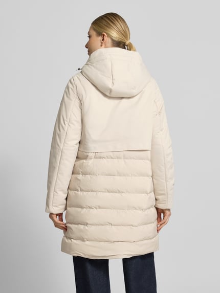 Frauenmodel trägt Regular Fit Steppmantel mit Eingrifftaschen von camel active in Beige mit Kapuze und Steppnähten, Ganzkörperansicht Rückansicht. Rückenlänge 93 cm, Schulterbreite 43 cm, Brustweite 56 cm, Ärmellänge 66 cm.
