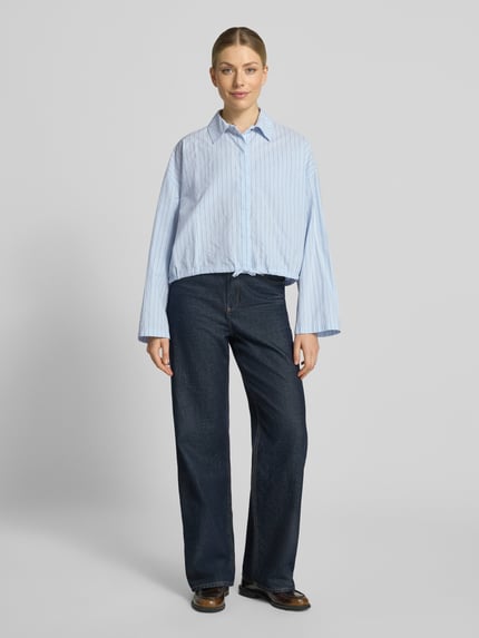 Vrouwenmodel draagt Boxy Fit blouse met overhemdkraag en verborgen knoopsluiting Model 'FIONEL' van DRYKORN, puur katoen, tunnelkoord, Ruglengte maat 36: 54 cm, mouwlengte maat 36: 50 cm, lichtblauw met fijne strepen, textuur glad, voorkant gehele lichaam