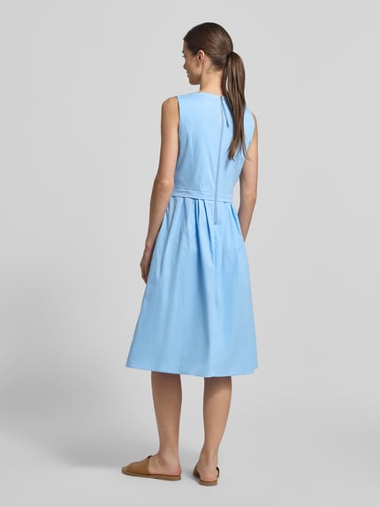 Frauenmodel trägt Midikleid mit Rundhalsausschnitt von ROBE LÉGÈRE aus hellblauem Baumwoll-Mix, A-Linie, Falten, Ganzkörperansicht Rückansicht.