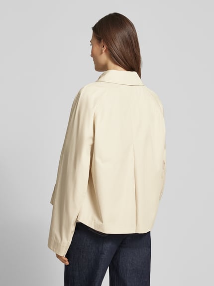 Frauenmodel trägt Relaxed Fit Trenchcoat aus reiner Baumwolle von Tommy Hilfiger in Beige, unifarben, Twill-Textur, wasserabweisend, Ganzkörperansicht Rückansicht.