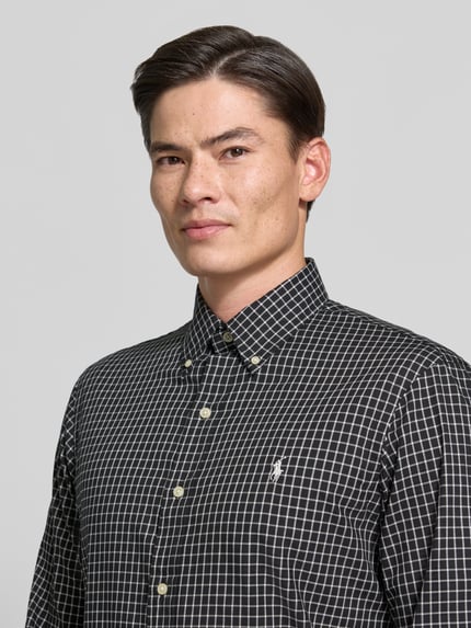 Männermodel trägt Custom Fit Freizeithemd aus reiner Baumwolle von Polo Ralph Lauren in Schwarz mit weißem Karomuster, Nahaufnahme Oberkörper.