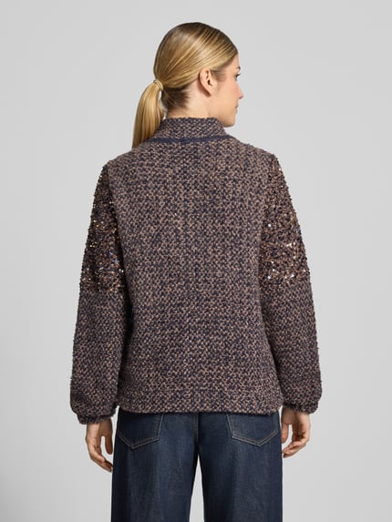 Männermodel trägt Regular Fit Strickjacke mit Pailletten von monari in Mieszanka bawełny z dodatkiem wełny, stójka, zamek błyskawiczny dwustronny, kolor granatowo-brązowy, cekiny na rękawach, długość tyłu w rozmiarze 36: 57 cm, długość rękawów w rozmiarze 36: 67 cm, Ganzkörperansicht Rückansicht