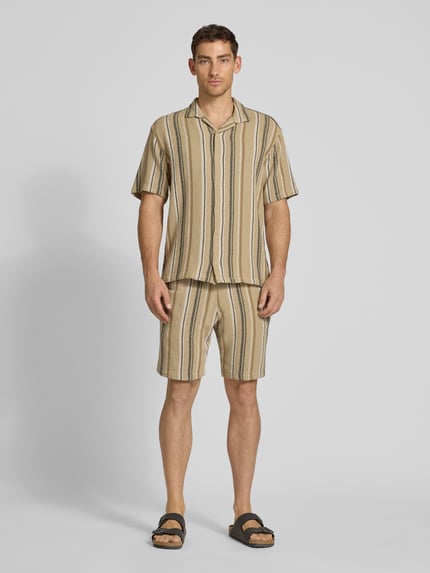 Männermodel trägt Regular Fit Freizeithemd mit Kentkragen von MCNEAL, beige mit schwarzen Streifen, reine Baumwolle, Ganzkörperansicht von vorne.