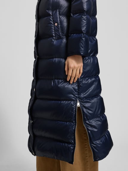 Kobiece model prezentuje Daunenmantel mit Stehkragen und seitlichen Reißverschlüssen od Lauren Ralph Lauren, granatowy, pikowana tekstura, boczne suwaki, długie rękawy, proste cięcie, zbliżenie na dolną część płaszcza.