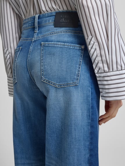 Vrouwenmodel draagt Wide Fit Jeans in verkorte pasvorm Model 'Oria' van Cambio, mix van katoen en elastaan, 5-pocketmodel, knoop- en ritssluiting, detailopname rugaanzicht.