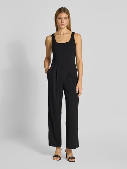 Frauenmodel trägt Jumpsuit mit Rundhalsausschnitt von Calvin Klein Womenswear in Schwarz, Regular Fit, glatte Textur, Ganzkörperansicht von vorne.