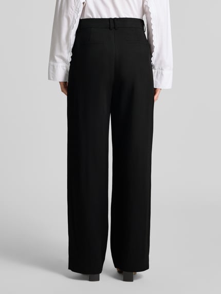 Frauenmodel trägt Wide Fit Hose mit Viskose-Anteil Modell 'Ailyn' von Cph Muse in Schwarz, glatte Struktur, Ganzkörperansicht Rückansicht, Bundweite 40 cm, Innenbeinlänge 80 cm.