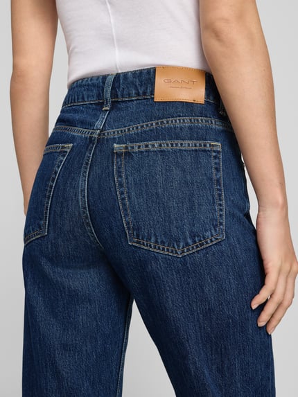 Frauenmodel trägt Relaxed Fit Jeans aus Baumwoll-Lyocell-Mix von GANT, dunkelblauer Denim, sichtbare Nähte, Nahaufnahme Rückansicht, Damen Relaxed Fit Jeans von GANT.