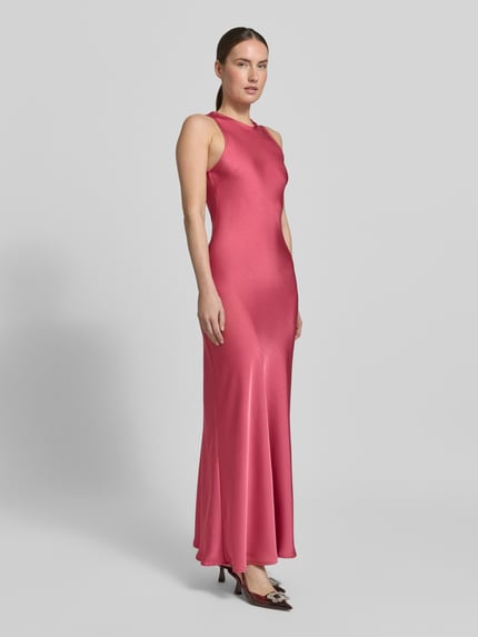 Frauenmodel trägt Abendkleid mit rückseitigem Schlüsselloch-Ausschnitt von Neo Noir aus Satin im Körpernaher-Schnitt, Maxikleid, Modell 'Celinie', Rundhalsausschnitt, seidig-glänzende Textur, Ganzkörperansicht von vorne. Rückenlänge Größe 36: 152 cm, Brustweite: 36 cm.