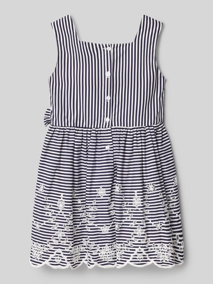 Mädchen trägt Regular Fit Kleid mit floralem Stitching von DANAMADE aus Reine Baumwolle, dunkelblau-weiß gestreift mit Lochmuster, Zierschleife, Ärmelloses-Design, Rückenlänge bei Größe 116: 62 cm, Ganzkörperansicht Rückansicht.