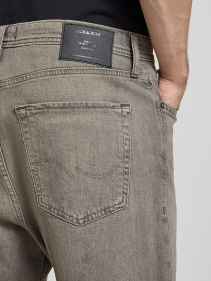 Männermodel trägt Relaxed Fit Jeansshorts Modell 'TONY' von Jack & Jones aus Baumwoll-Elasthan-Mix mit Eingrifftaschen, Nahaufnahme Rückansicht. Bundweite bei Größe M: 42 cm, Innenbeinlänge: 21 cm.