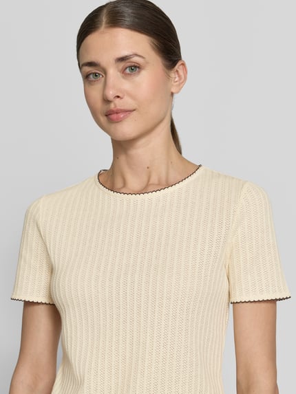 Vrouwenmodel draagt gebreid shirt met ronde hals van Jake*s collectie, puur katoen, recht model, semi-transparante look, nahaufnahme bovenlichaam.