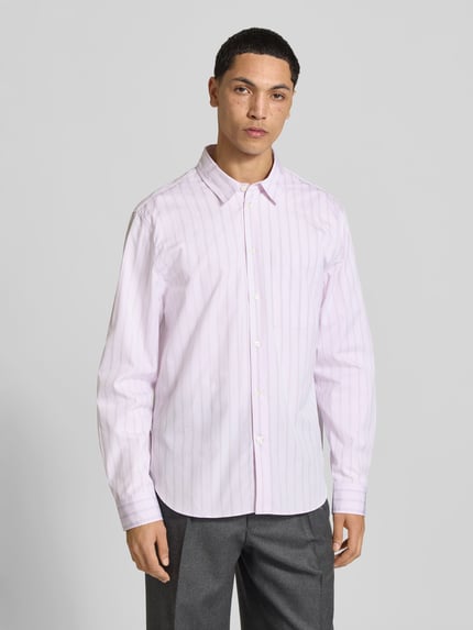 Męski model ma na sobie Relaxed Fit Freizeithemd aus Baumwolle od MAISON KITSUNÉ, jasnoróżowe paski, nakładana brustasza, listwa guzikowa na całej długości, krój relaxed fit, czysta bawełna, długość tyłu w rozmiarze M: 74 cm, szerokość w rozmiarze M: 49 cm, długość rękawów w rozmiarze M: 68 cm, widok całej sylwetki z przodu.
