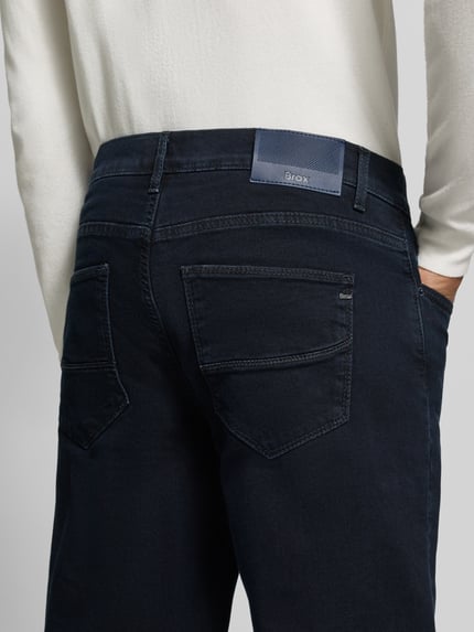 Männermodel trägt Straight Fit Jeans Modell 'Cadiz' von Brax in dunklem Denim mit Label Patch, 5-Pocket-Design, Nahaufnahme Rückansicht, Baumwoll-Mix.