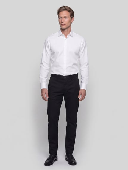 Männermodel trägt weißes Regular Fit Businesshemd aus reiner Baumwolle Modell 'H-Joe-K-C1' von BOSS, Herren Businesshemd, Ganzkörperansicht von vorne.