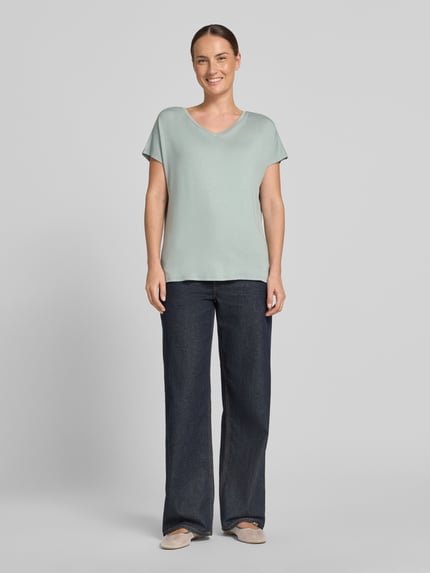 Frauenmodel trägt T-Shirt aus Viskose-Elasthan-Mix mit V-Ausschnitt von Christian Berg Woman, Relaxed-Fit, Kappärmel, Rückenlänge 63 cm, Ganzkörperansicht von vorne.