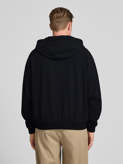 Męski model nosi Relaxed Fit Sweatjacke aus reiner Baumwolle Modell 'Hootailored262X' von HUGO, efekt: jednolity kolor, dzianina dresowa, zamek błyskawiczny, detal z logo, kaptur z tunelowym ściągaczem, okrągły dekolt, długi rękaw, prążkowane wykończenie, nakładana boczna kieszeń, wykończenie: prążkowane, materiał: czysta bawełna, ganzkörperansicht rückansicht.
