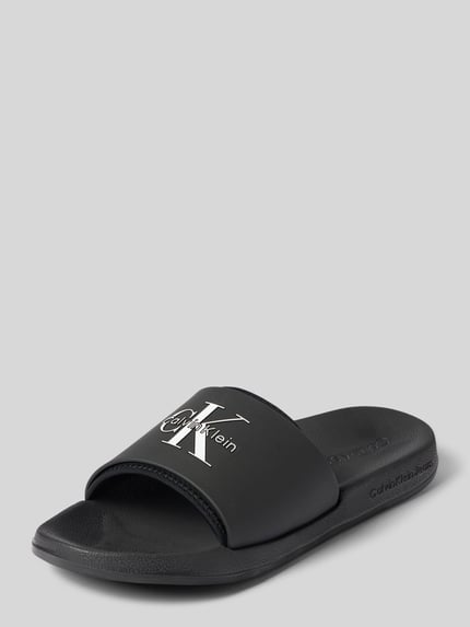Produktfoto, Badeschuhe mit Label-Prägung von CK Calvin Klein, schwarzes Design, glatte Oberfläche, Herren Badeschuhe