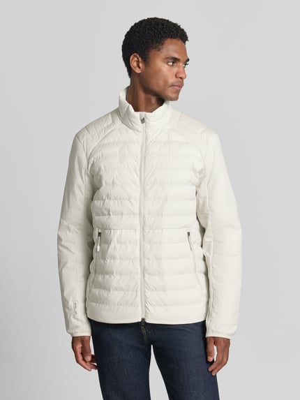 Männermodel trägt Regular Fit Sweatjacke mit Steppdetails von Polo Ralph Lauren in Creme mit glatter und gesteppt strukturierter Oberfläche, Ganzkörperansicht von vorne. Herren Sweatjacke von Polo Ralph Lauren.