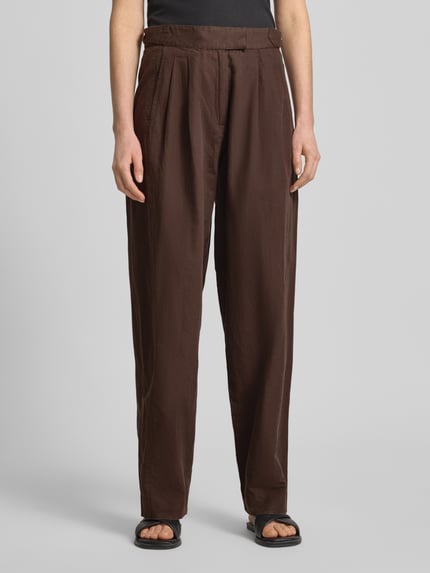 Frauenmodel trägt Wide Leg Hose mit Eingrifftaschen Modell 'QUINN' von Scotch & Soda, brauner Baumwoll-Leinen-Mix, Nahaufnahme Oberkörper bis Füße, Damen Hose.