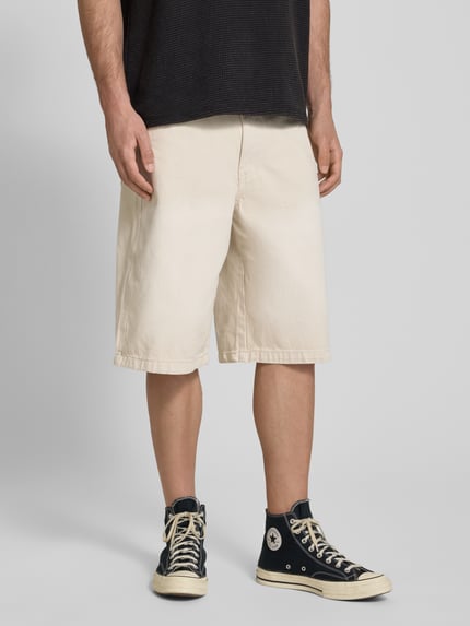 Männermodel trägt Straight Fit Shorts in Denim-Optik Modell 'Kolar' von PEGADOR aus Reiner Baumwolle, 5-Pocket-Design, Nahaufnahme Unterkörper.