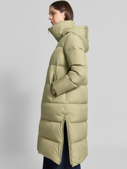 Vrouwenmodel draagt regular fit lange donsjas Regular Fit Daunenmantel mit abnehmbaren Rucksackriemen van Marc O'Polo in lichtgroen, zijaanzicht, Dames Daunenmantel von Marc O'Polo.