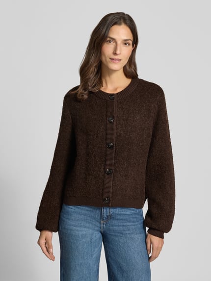 Frauenmodel trägt Strickjacke aus Viskose-Mix Modell 'Taile Nerida' von MSCH Copenhagen in Dunkelbraun, Knopfleiste, Relaxed Fit, Ganzkörperansicht von vorne. Damen Strickjacke, Rundhalsausschnitt, Woll-Anteil, Rückenlänge 54 cm, Ärmellänge 66 cm.