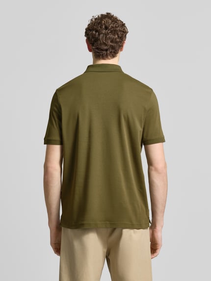 Männermodel trägt Regular Fit Poloshirt mit Logo-Stitching von Fynch-Hatton in Olivgrün, reine Baumwolle, Rückenansicht, Ganzkörperansicht Rückansicht.