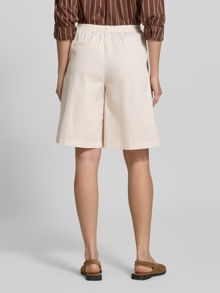 Vrouwenmodel draagt Bermudas met Gesäßtasche model 'ROVENA' van Soyaconcept uit een mix van katoen en elastaan, regular fit, achterzak, knoop- en ritssluiting, bandwijdte maat 36: 37 cm, binnenbeenlengte maat 36: 26 cm, crème kleur, rechte vormen, zachte textuur, Ganzkörperansicht Rückansicht.