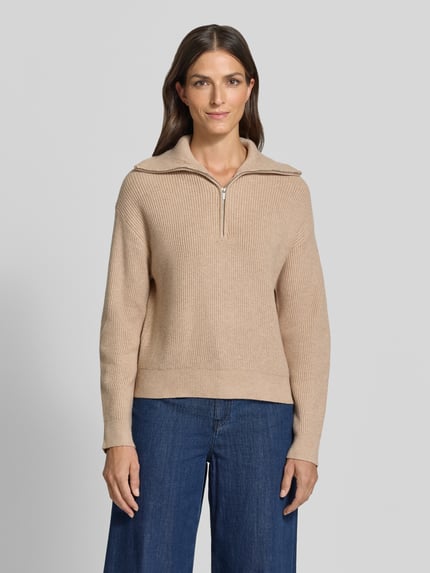 Frauenmodel trägt beigen Troyer aus Viskose-Mix mit gerippten Abschlüssen Modell 'RIZON' von MANGO, Ganzkörperansicht von vorne. Regular Fit, Troyer-Kragen, Rückenlänge 50 cm, Ärmellänge 52 cm.