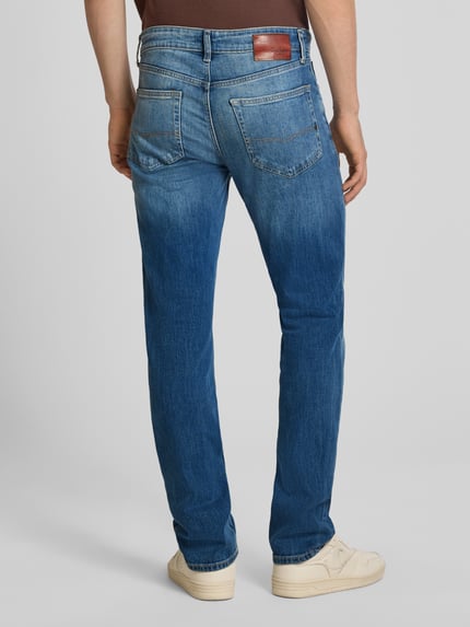 Männermodel trägt Slim Fit Jeans aus Baumwoll-Mix Modell 'Hatch' von Pepe Jeans, mittleres Blau, Herren Slim Fit Jeans, Ganzkörperansicht Rückansicht.
