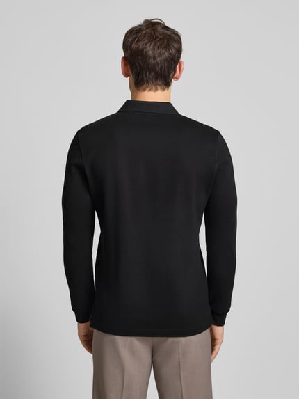 Męski model nosi czarne Poloshirt mit Label-Stitching Modell 'PAXTON' od Christian Berg Men, slim fit, bawełna, tył, pełna sylwetka.