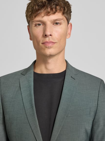 Männermodel trägt Slim Fit Sakko mit Viskose-Anteil Modell 'S PURE' von s.Oliver BLACK LABEL, graugrün, feine Struktur, Nahaufnahme Oberkörper.