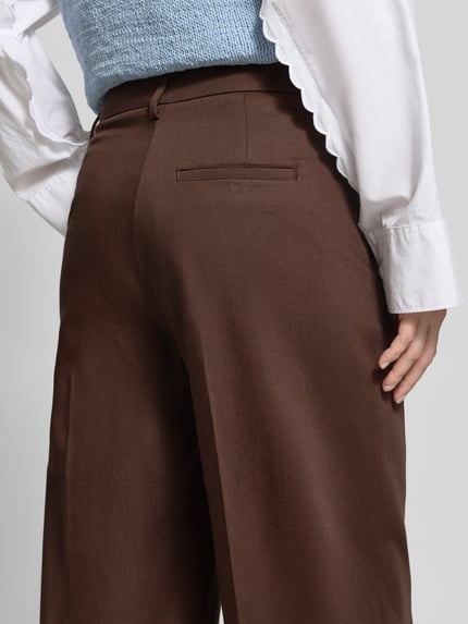 Frauenmodel trägt Weite Hose aus Lyocell-Mix Modell 'LEANDRAA' von ARMEDANGELS in Braun, glatte Textur, Detailaufnahme Rückansicht, Damen Weite Hose von ARMEDANGELS.