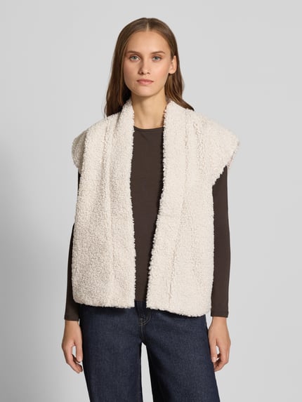 Modelka nosi kremową kamizelkę o kroju regular fit w stylu imitacji futerka Regular Fit Weste in Teddy-Optik Modell 'NAYA' od ONLY, widok całej sylwetki z przodu, damska kamizelka od ONLY.