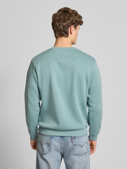 Männermodel trägt Sweatshirt mit gerippten Abschlüssen Modell 'BRADLEY' von Jack & Jones, Regular Fit, Hellblau, Ganzkörperansicht Rückansicht.