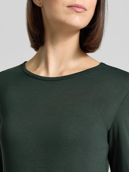 Vrouwenmodel draagt shirt met lange mouwen van mix van viscose en elastaan Model 'Liana' van FREE/QUENT, donkergroen, ronde hals, slim fit, dames, detailopname bovenlichaam, ruglengte bij maat S 59 cm.