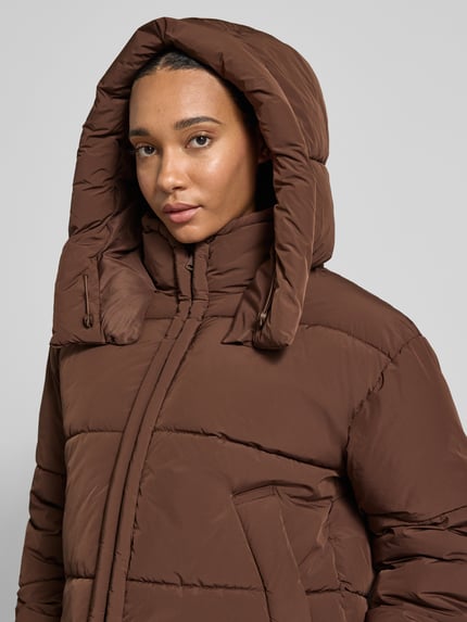 Frauenmodel trägt Bomberjacke mit Kapuze Modell 'ONLCORNELIA' von ONLY in Braun, strukturierte Optik, Reißverschlüsse, Nahaufnahme Oberkörper