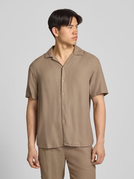 Männermodel trägt Regular Fit Freizeithemd aus Viskose-Leinen-Mix Modell 'LATHAM' von Only & Sons, unifarben, strukturierte Optik, Resortkragen, durchgehende Knopfleiste, Kurzarm, Ganzkörperansicht von vorne.