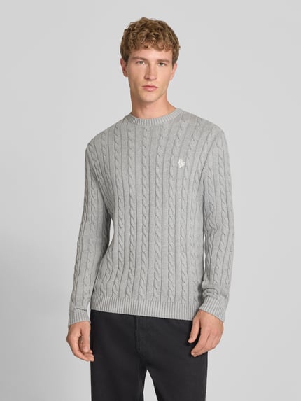Męski model nosi Slim Fit Strickpullover reine Baumwolle od REVIEW, szary, Ścieg warkoczowy, wyhaftowane logo, prążkowane ściągacze, Ganzkörperansicht von vorne