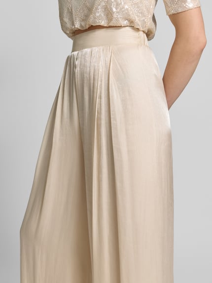 Frauenmodel trägt Wide Leg Hose aus fließendem Stoff mit elastischem Bund von Rinascimento, schimmernd, beigefarben, Nahaufnahme Oberkörper.