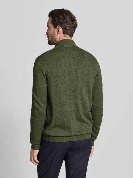 Męski model nosi Strickjacke mit Reißverschluss von Christian Berg Men, zielony kolor, bawełna organiczna, luźny krój, widok całej sylwetki z tyłu.