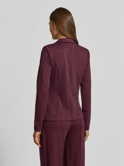 Vrouwenmodel draagt bordeauxroze blazer met structuurpatroon, Reverskraag, paspelzakken, knoopsluiting, Model 'Kate' van ICHI, getailleerde pasvorm, elastische materiaalmix met viscose, ruglengte maat S 59 cm, borstwijdte 38 cm, mouwlengte 63 cm, Ganzkörperansicht Rückansicht.