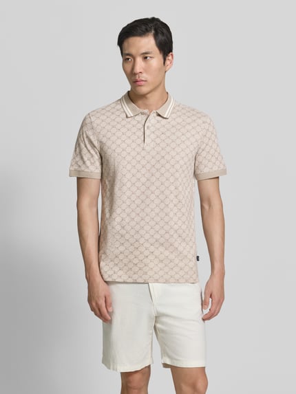 Männermodel trägt Regular Fit Poloshirt mit Logo-Muster Modell 'Jessino' von JOOP! Collection aus reiner Baumwolle, Ganzkörperansicht von vorne.