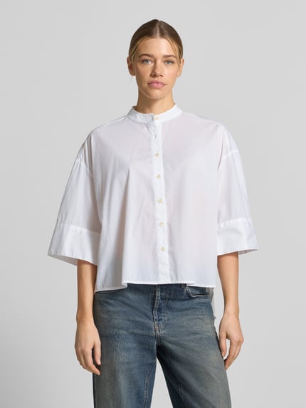 Frauenmodel trägt Boxy Fit Bluse mit Stehkragen und 3/4-Arm von Emily Van den Bergh aus Reine Baumwolle, weiße Farbe, Ganzkörperansicht von vorne.